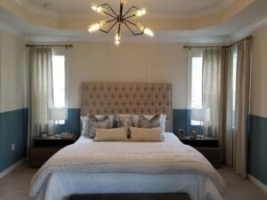 Stylish bedroom showcasing a tufted headboard, modern lighting, and neutral decor.